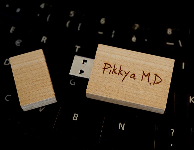 Clé USB en bois rectangulaire personnalisée sur un clavier.